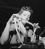 Miss Genie Lee Neal reading a perforated tape at the Western Union telegraph office. Washington, DC. June 1943. FSA/OWI Collection